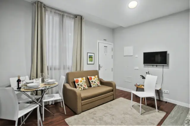Salón compacto del apartamento LEMON junto a la ventana